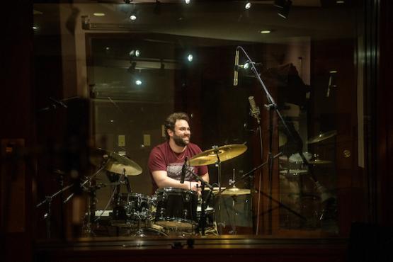 Student plays a drumset in OHIO's audio studio 329