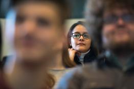 Student sits in audience, listening intently