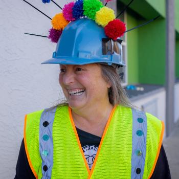 A photo of Patty Mitchell with a blue helmet with flowers on it for a Passion Works event