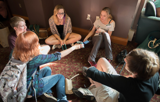 Students sharing with each other while sitting in a circle in a residence hall common area