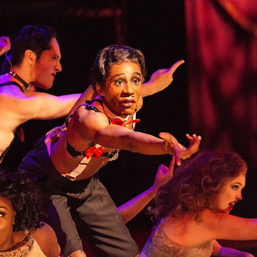 Performers sing on stage during a musical