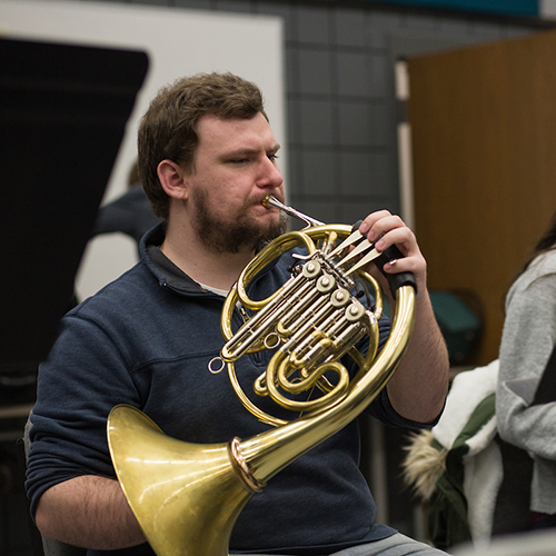 Student playing the French horn