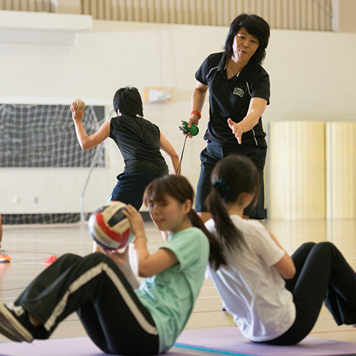 Students do exercises in a physical education class in a gymnasium