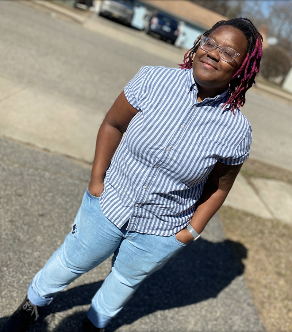 A student smiles with their eyes closed in the sunshine.