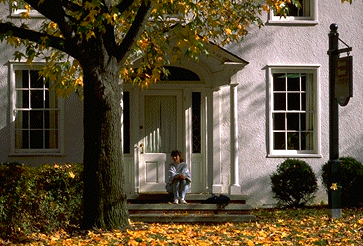 Photo of someone sitting on the front steps of Brown House, demolished in 2019