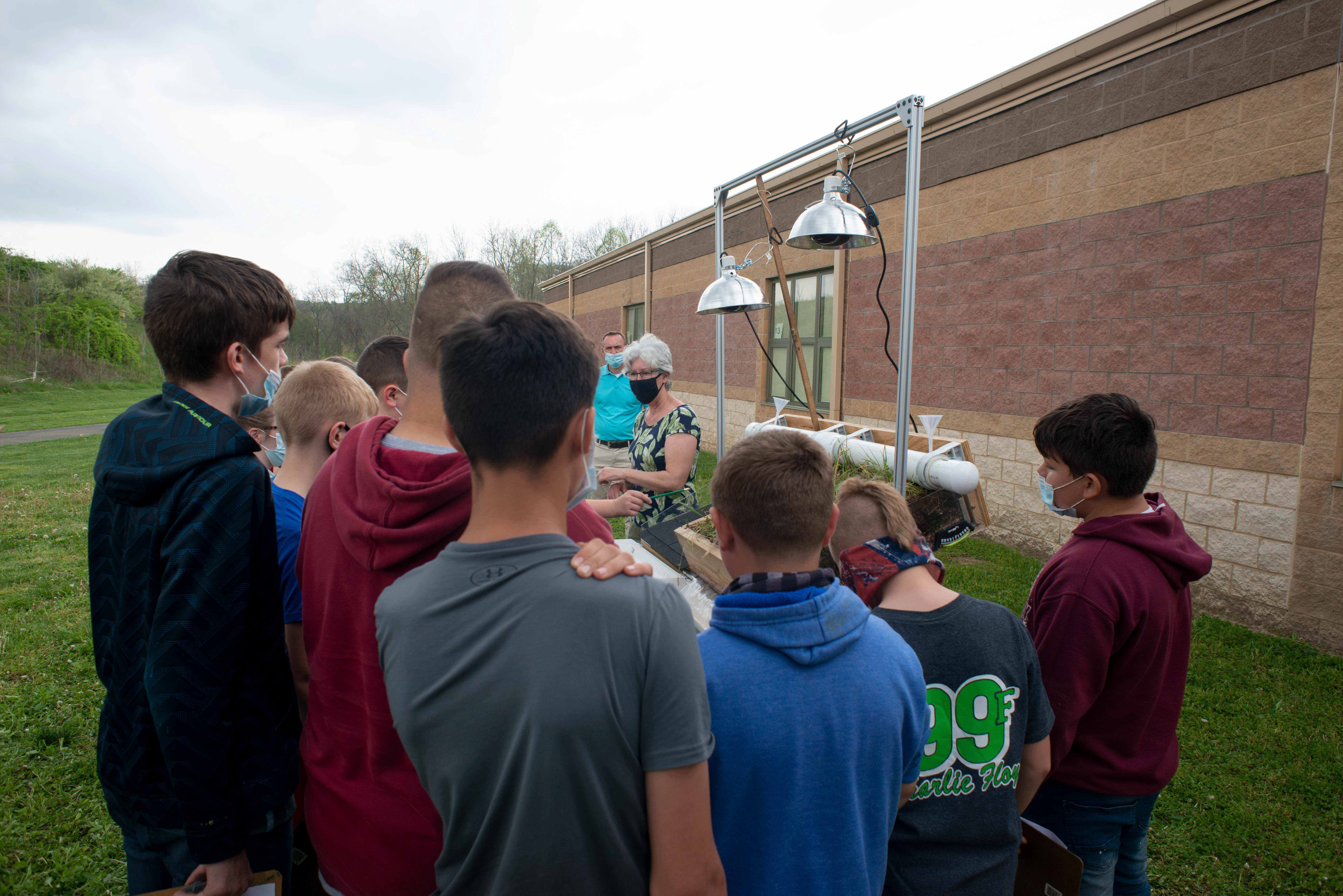 Students gather around Dr. Kim Thompson as she explains the green roof model at Vinton County Middle School.
