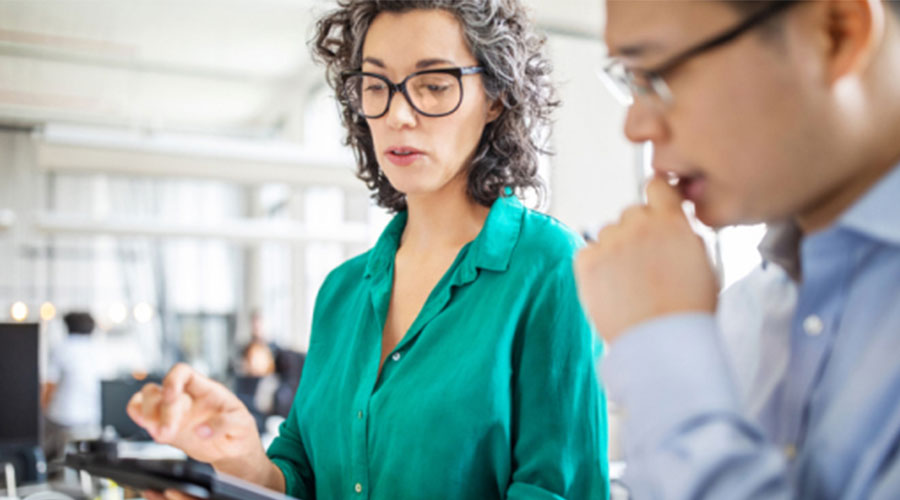 Woman in green shirt holding tablet in business analytics certificate class