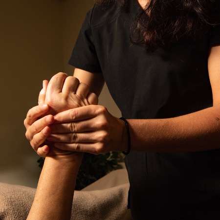 massage therapist massaging a hand