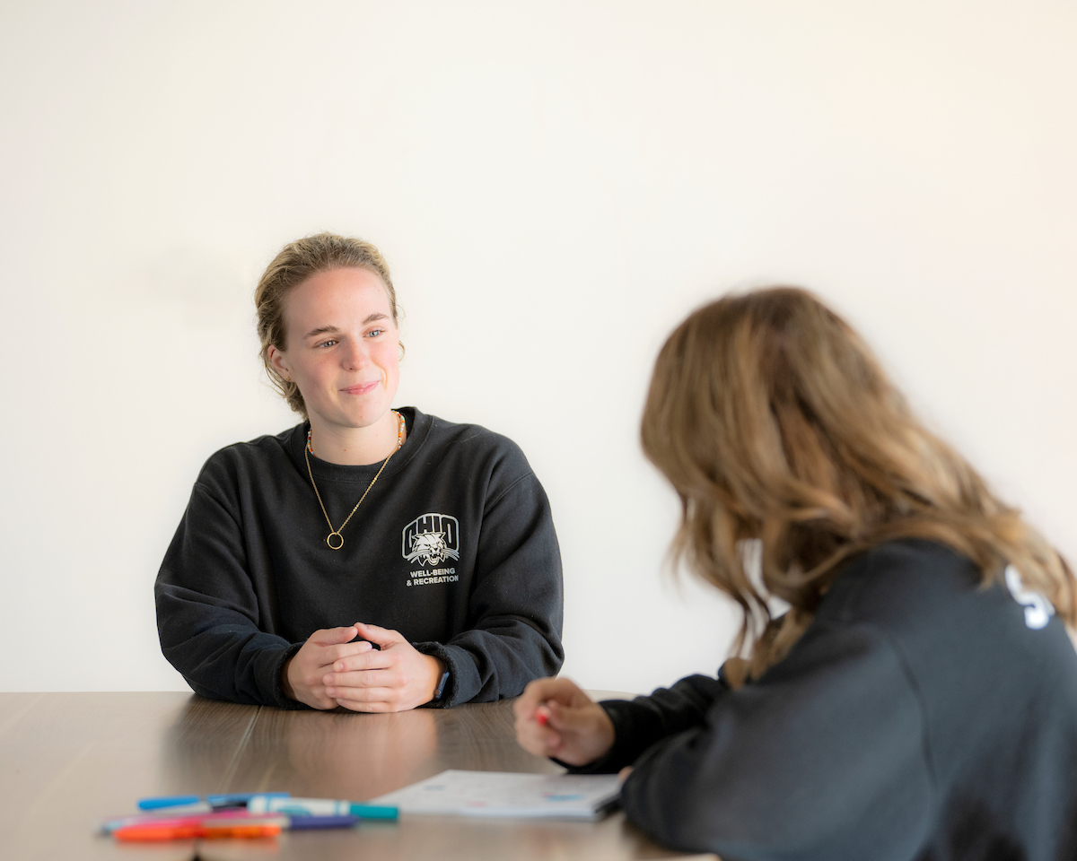 A woman interviewing another woman at a table