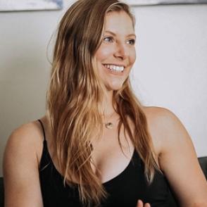 Carissa Nickell looks off-camera smiling and wearing a black tank top 