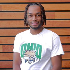 Roosevelt Boone smiles at the camera, wearing a white shirt and green  'OHIO' lettering as well as a logo of Rufus