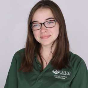 Taylor in a dark green Bobcat Student Orientation shirt, smiling at the camera.