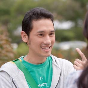 Student smiling with one finger raised