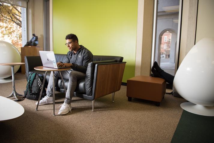 A student works alone on his laptop.