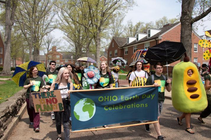 Students holding a banner and parading to celebrate Earth Day