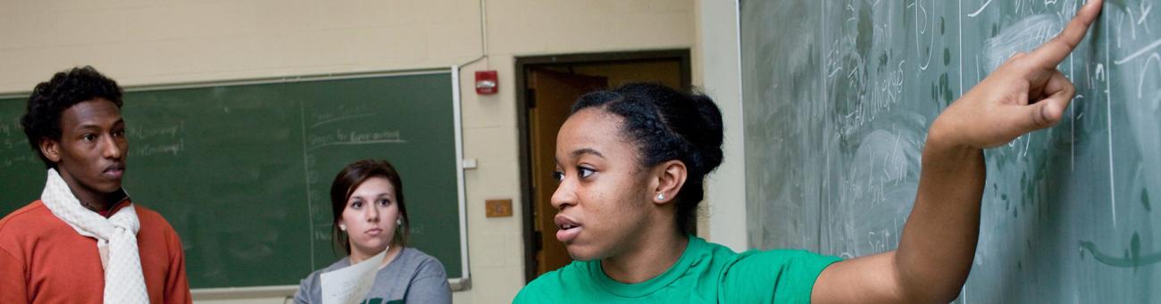 Students study together on a blackboard