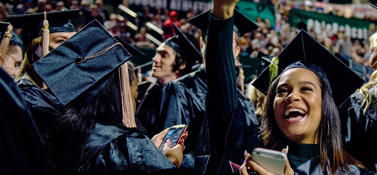 A female graduate celebrates on Commencement day.