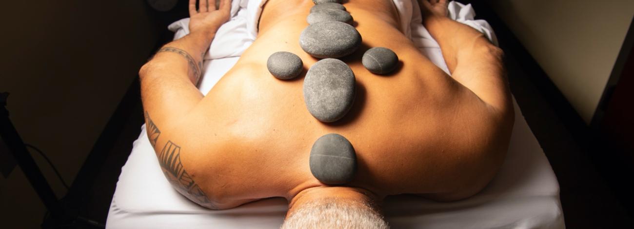 Massage client with hot stones on back