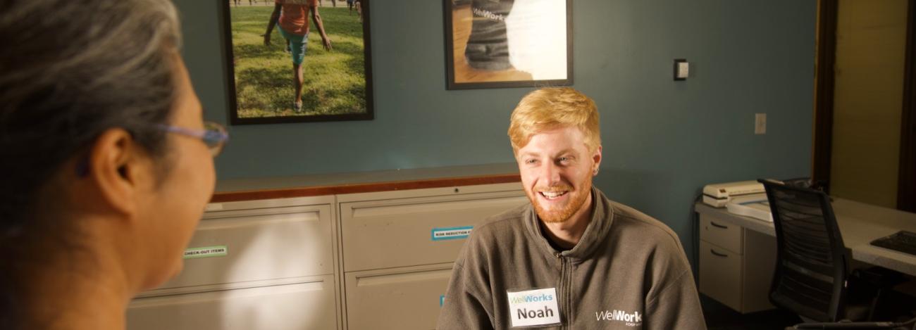 Student employee at front desk with WellWorks member