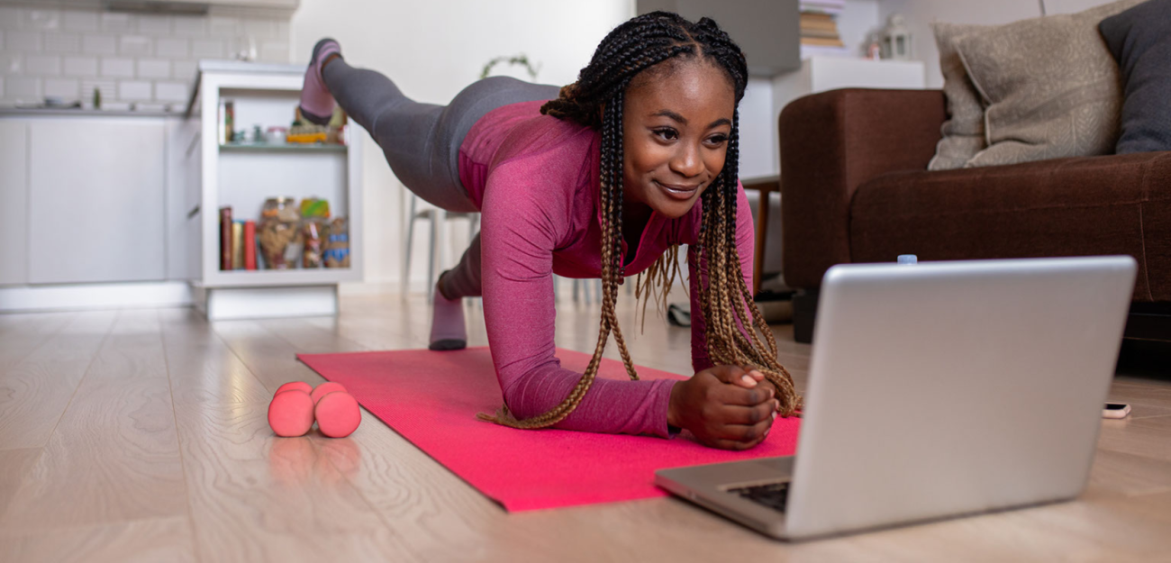 Woman exercising while looking at computer