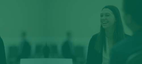 A woman in a blazer smiles during a career networking event. 