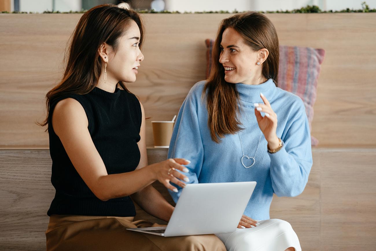 Two business women sitting in front of laptop