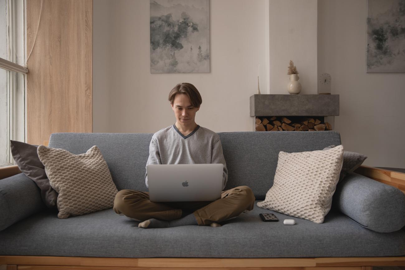 Man sitting on a couch with laptop in his lap