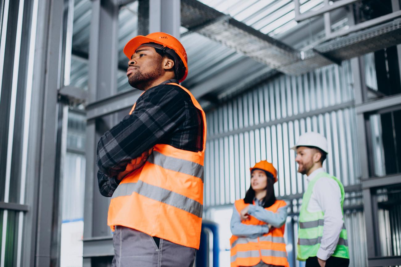 Three engineers look at manufacturing plan. Image by senivpetro on Freepik.