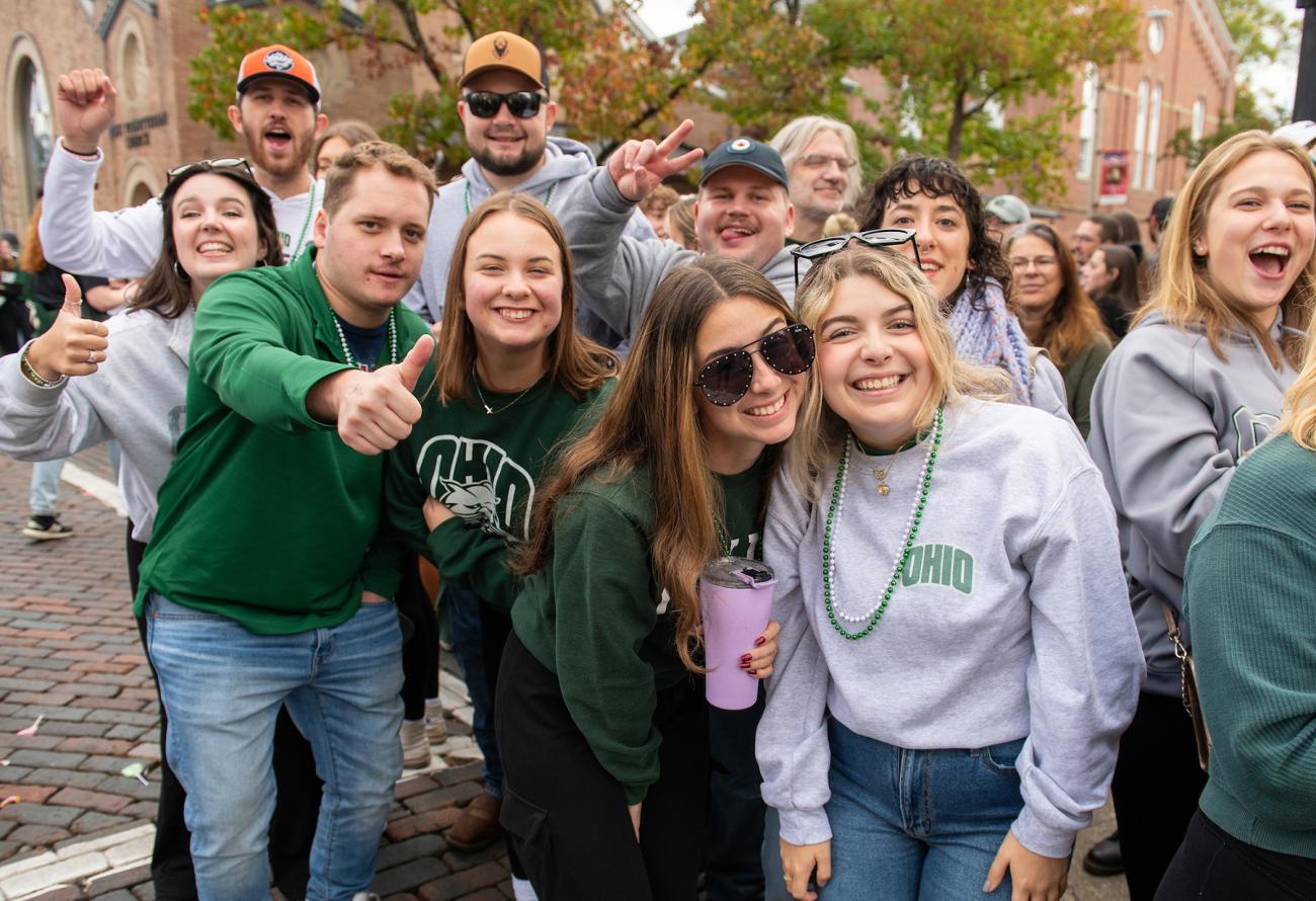 alumni + students cheering on at the Homecoming Parade