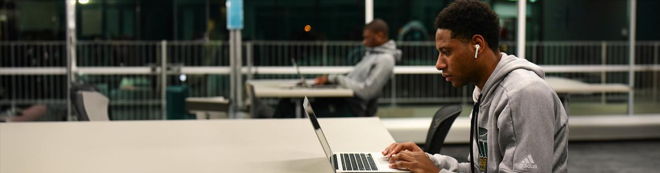 Man sits at laptop computer on a desk