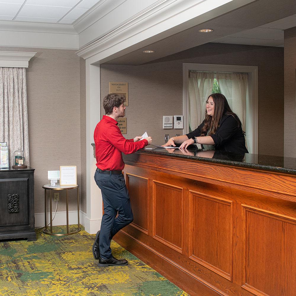 A hotel employee checks in a customer.