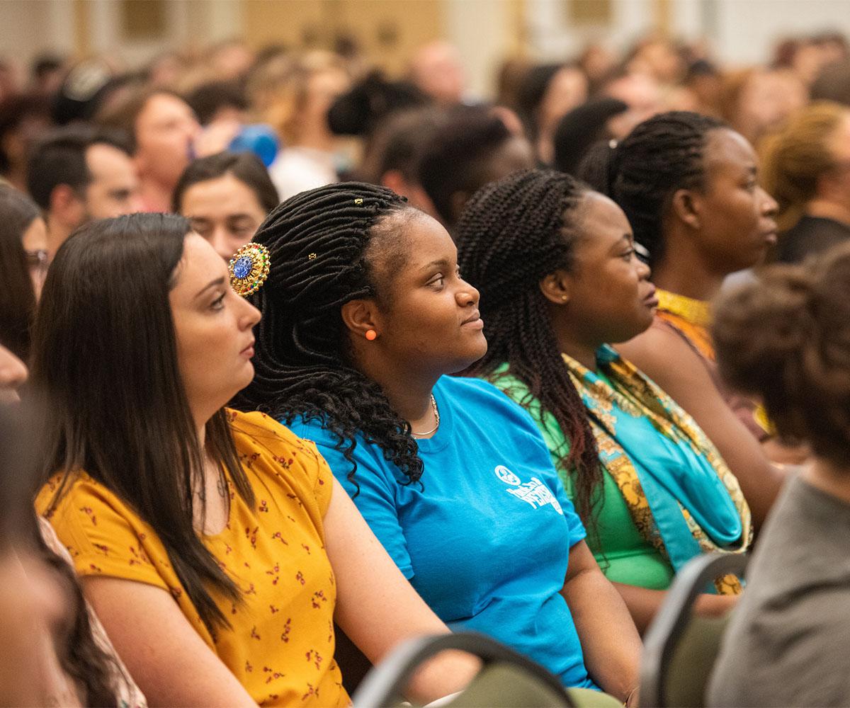 Students listen to a speaker during orientation.