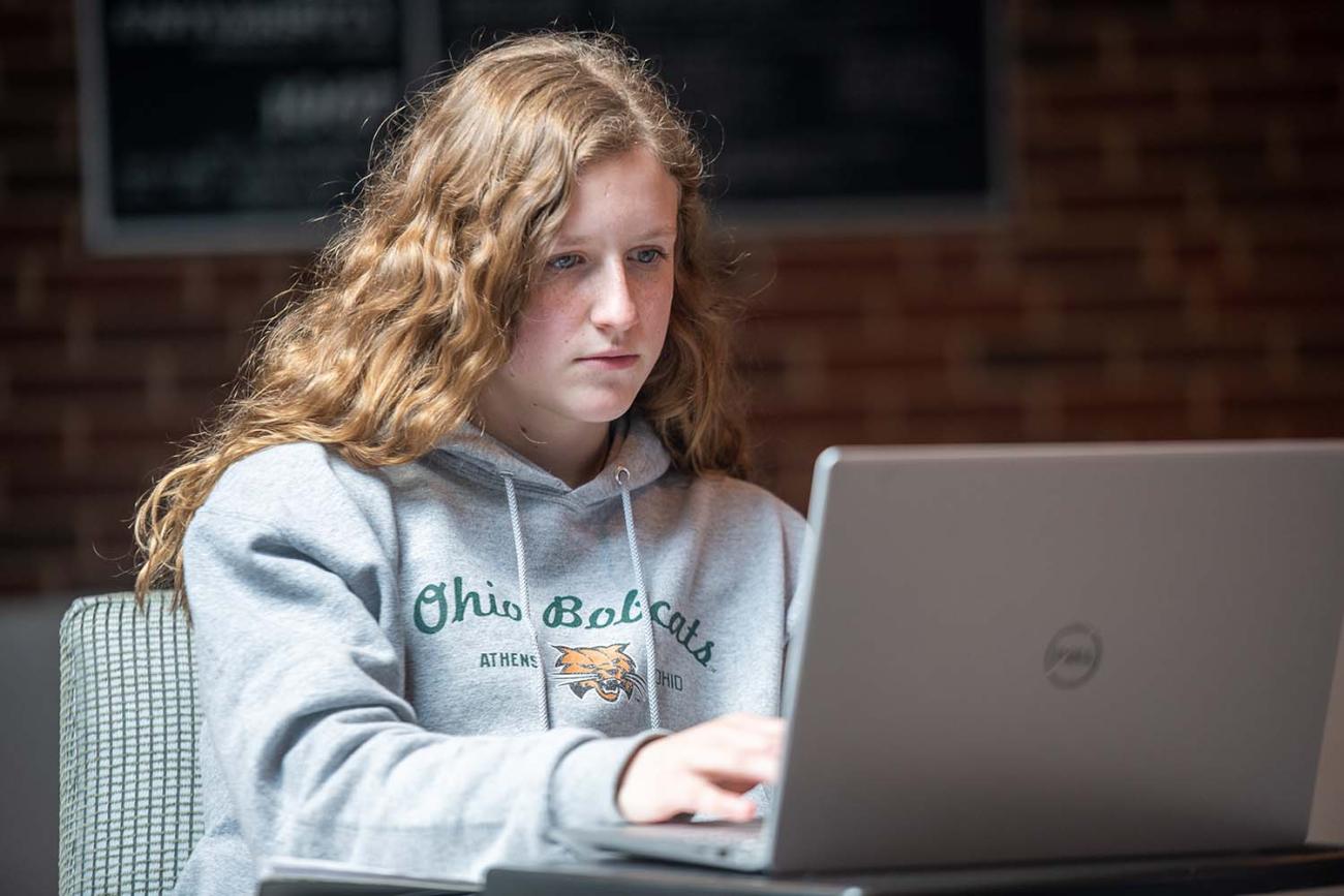 Woman sits with a laptop