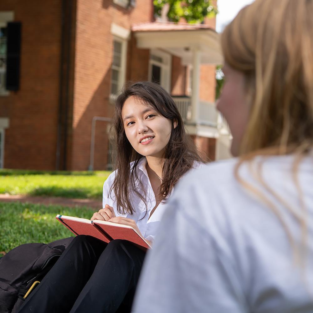 Two international students conversing outdoors.