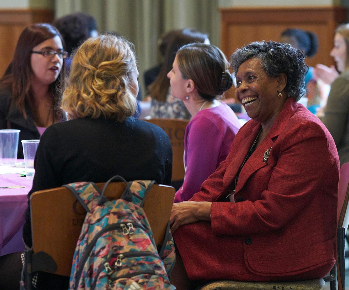 Faculty and staff talk to one another during a conference.