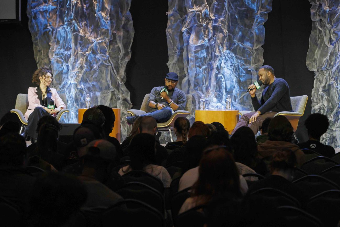 Three panelists on stage talking