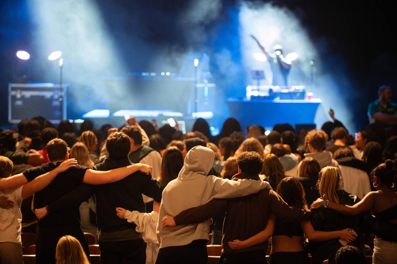 People put their arms around each other during a music concert