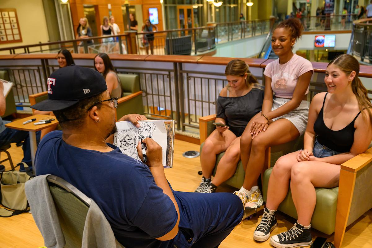 students getting their portrait drawn during a welcome week event