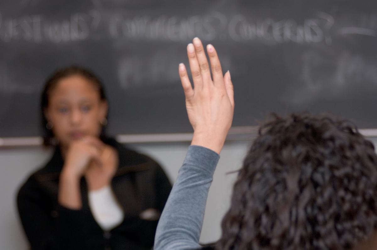 Student raising their hand in class