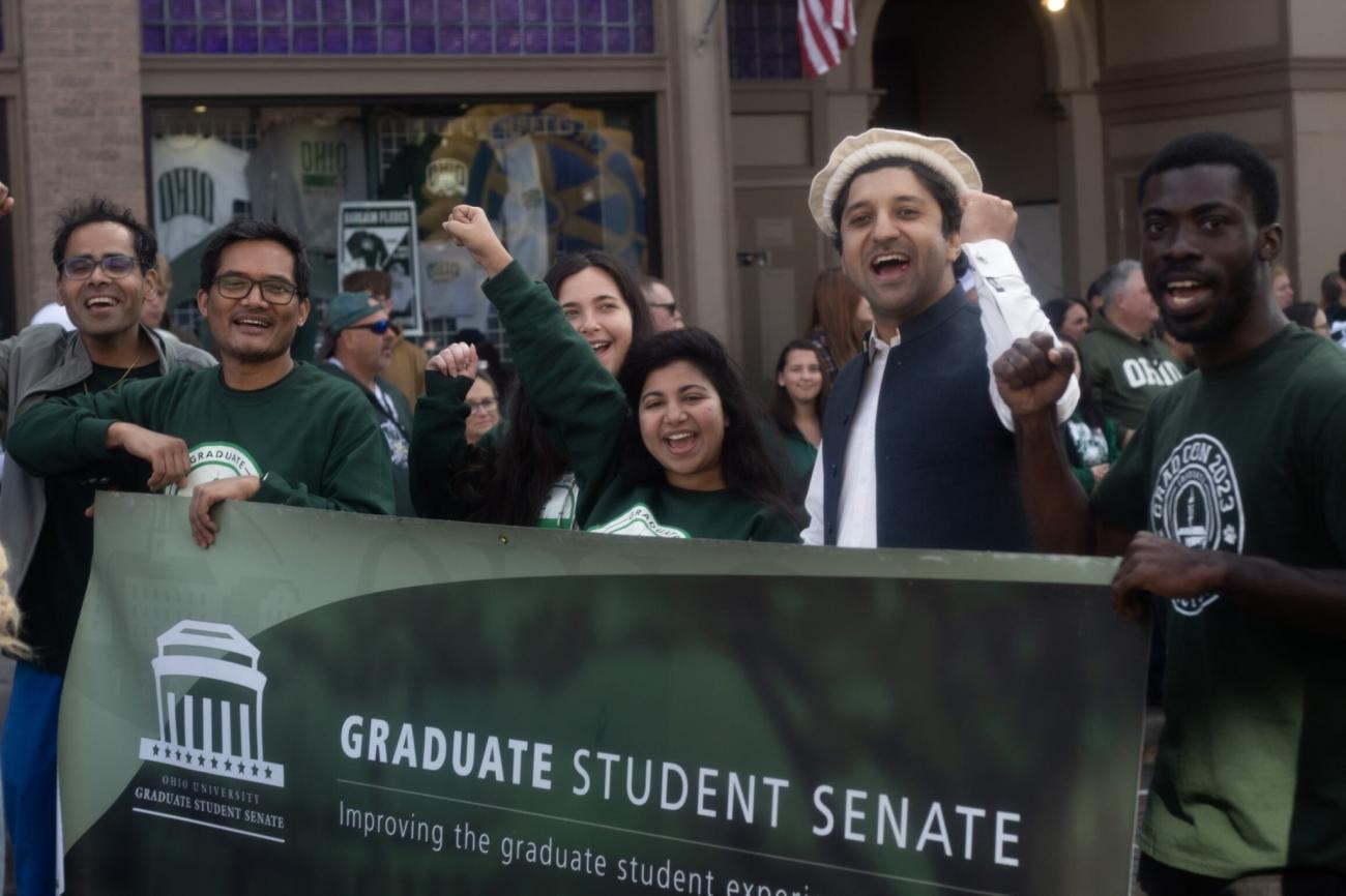 A group of students behind a Graduate Student Senate banner