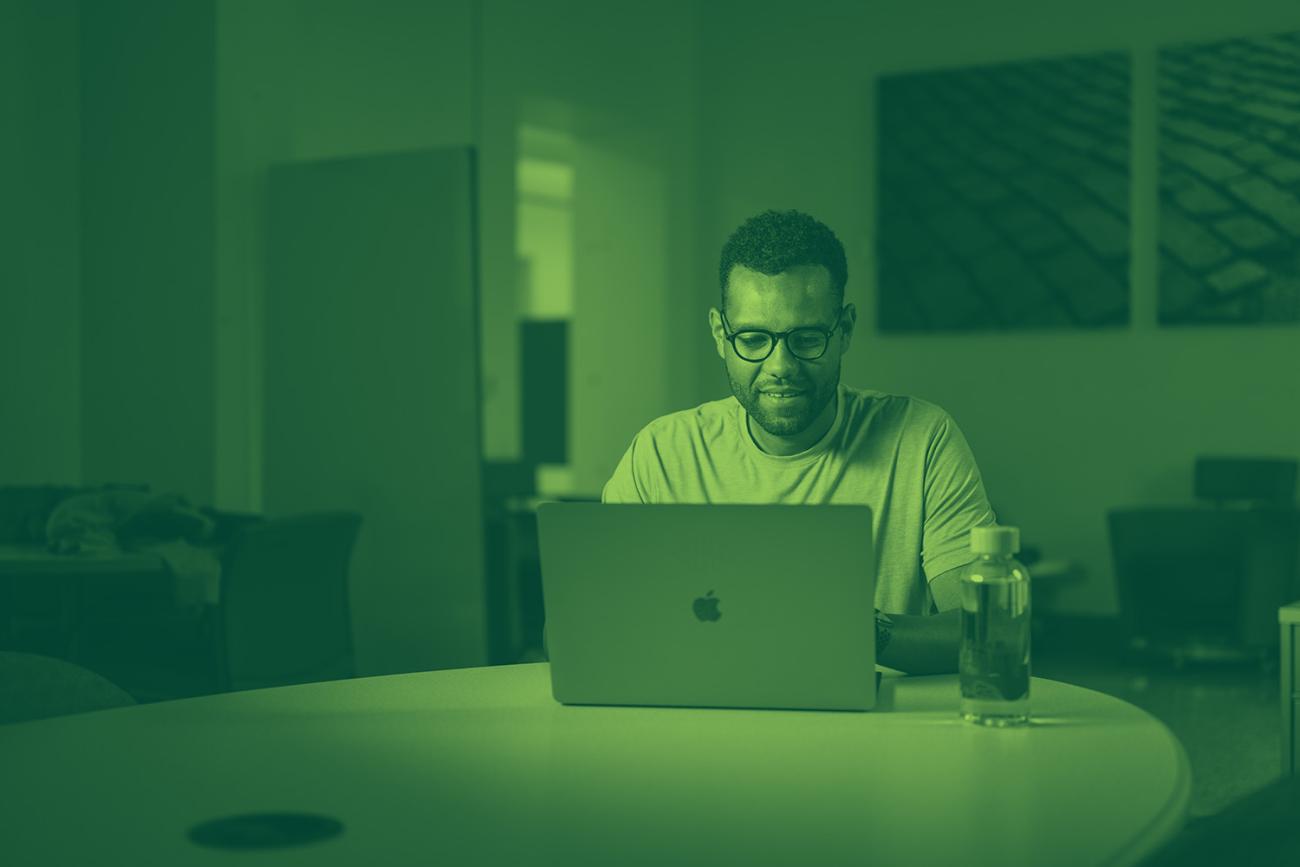 man sitting at a table with a laptop