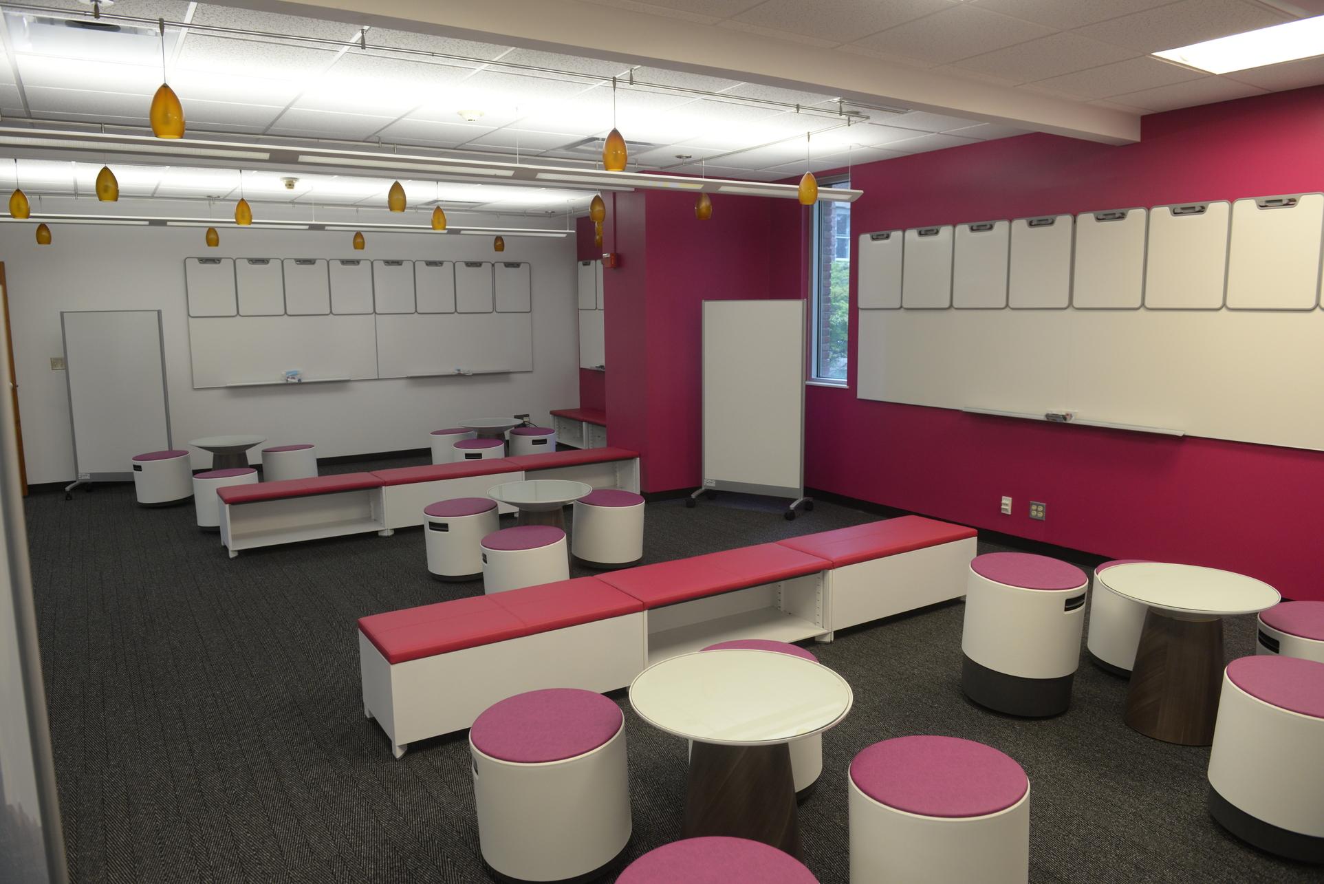 interior of the CoLab, pink and white furniture with gray carpeting