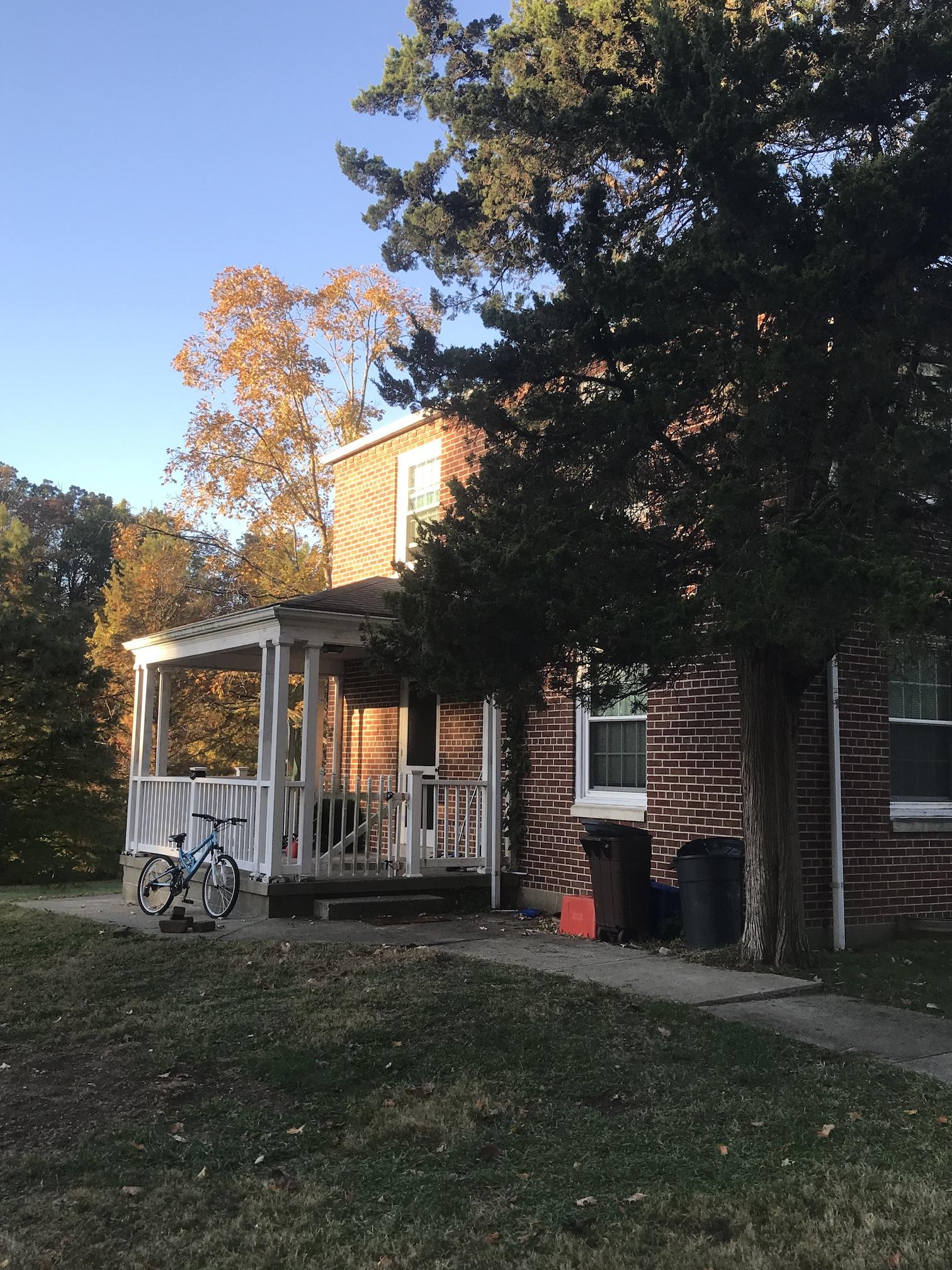 2-story brick building with trees and yard