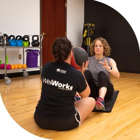 WellWorks personal trainer working out on floor with client