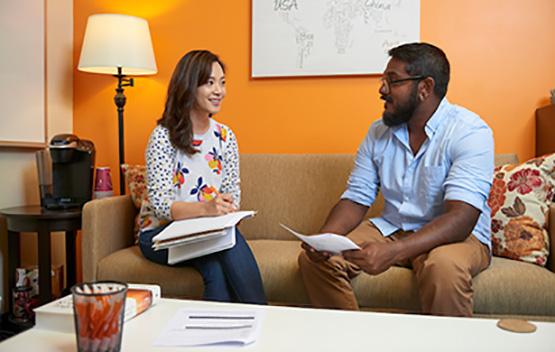 An advisor sits on a couch with an Ohio University student