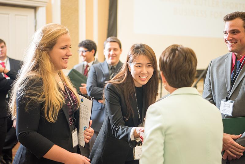 Business students shake hands with employers at a career fair