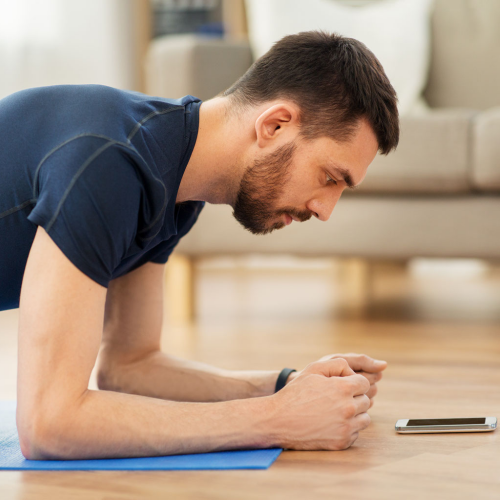 Man planking while looking at cell phone