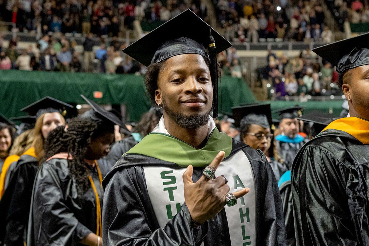 Student smiling at camera during graduation ceremony 