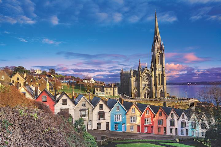 Tall cathedral building and multicolored houses in front.