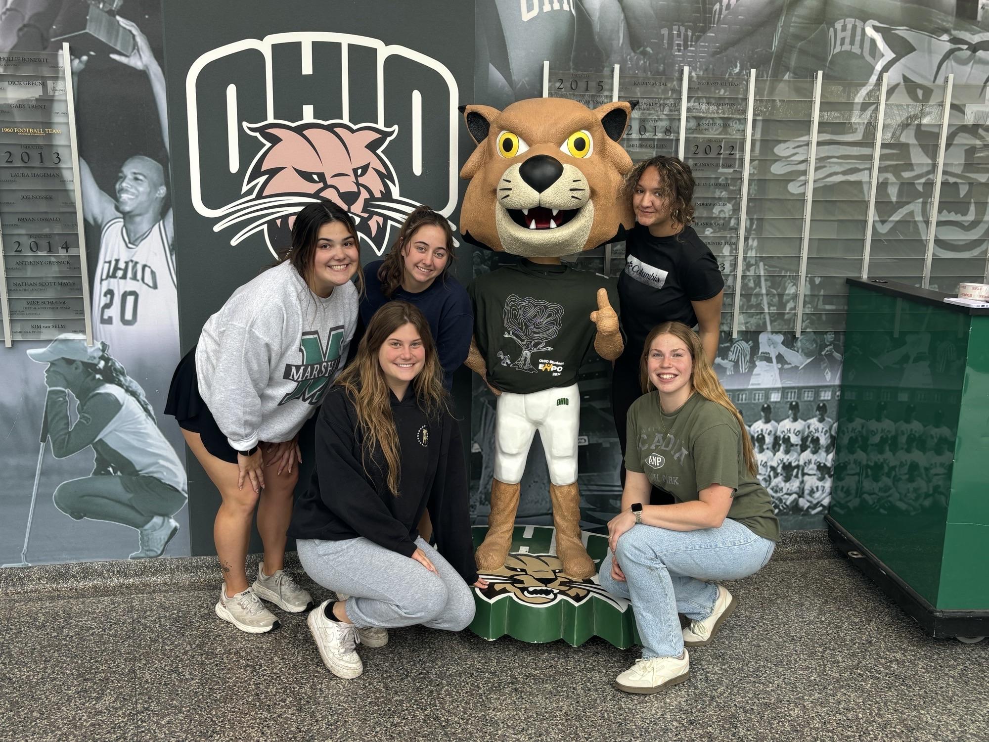 A group of students with a statue of Rufus the Bobcat